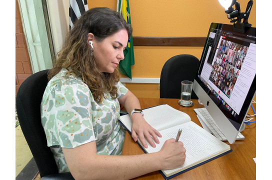 Reitora assina termo de posse em seu gabinete durante a cerimônia (Foto: Renata Biasioli)
